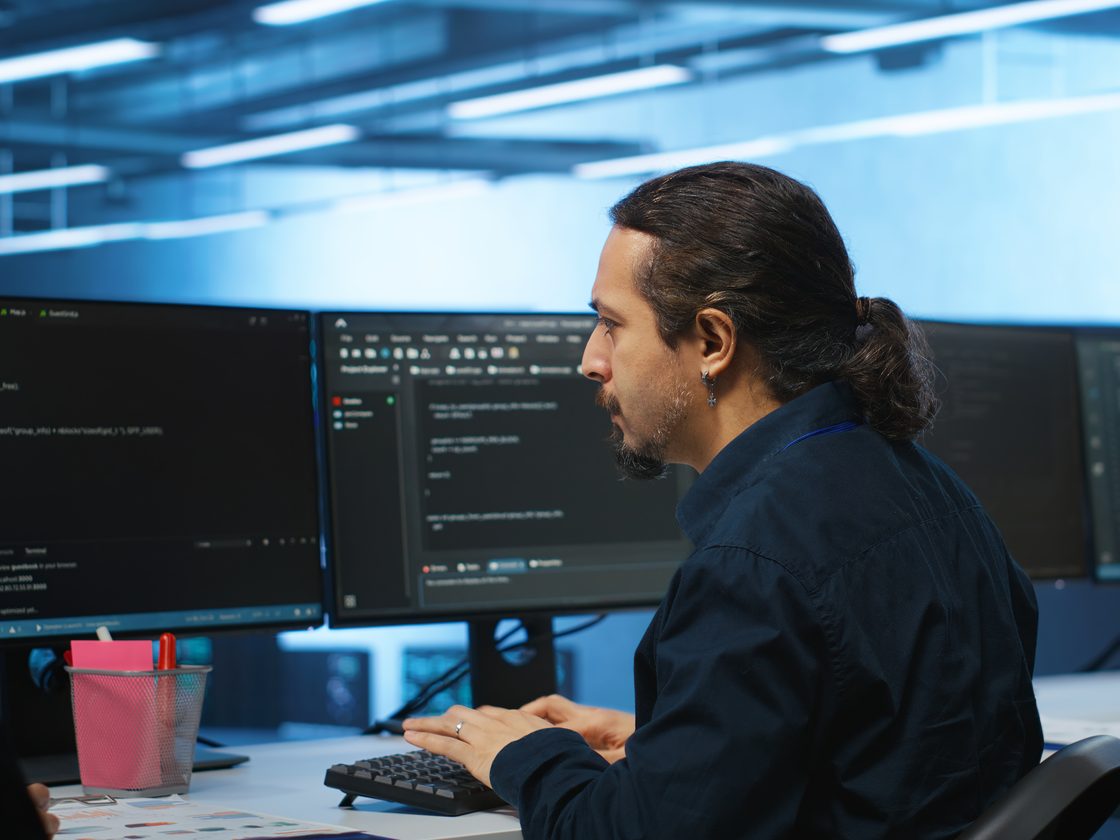 Two CoreNetHub engineers at a support desk, working at monitors
